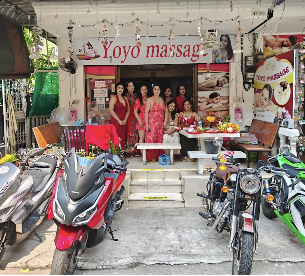 Yoyo Massage shopfront in Thailand with staff welcoming guests and scooters parked outside
